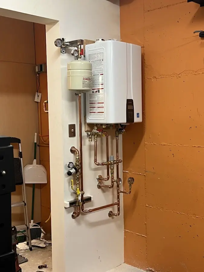 Plumbing technician inspecting water heater connections in Bryan